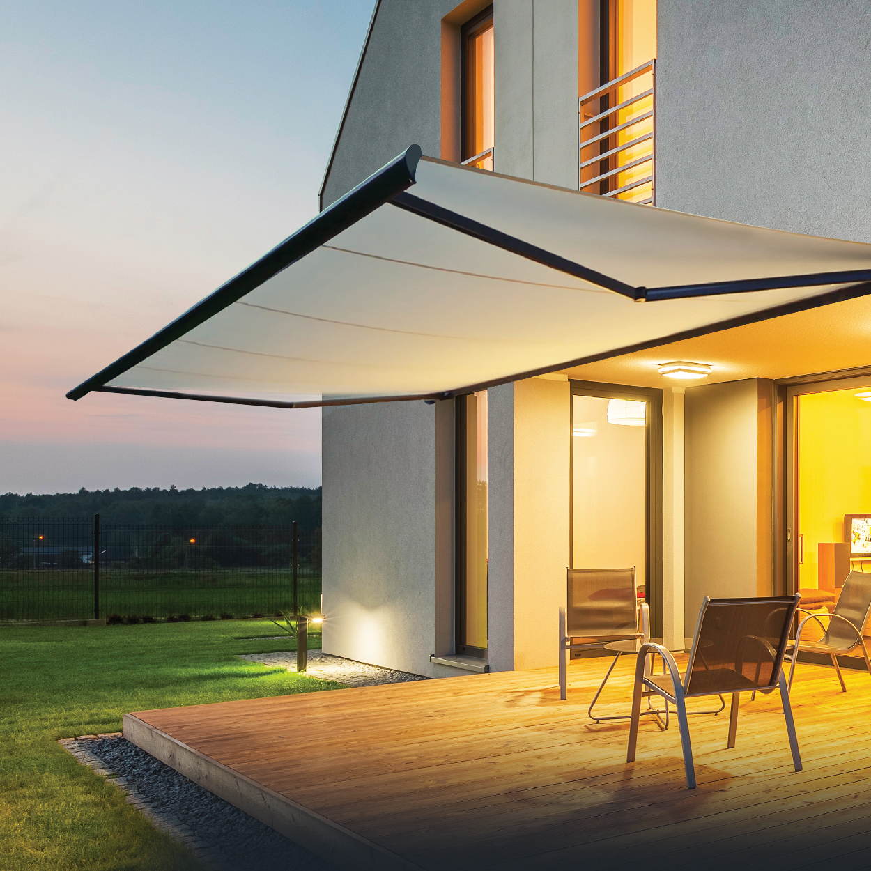 Toldo retráctil extendido sobre una terraza de madera al atardecer