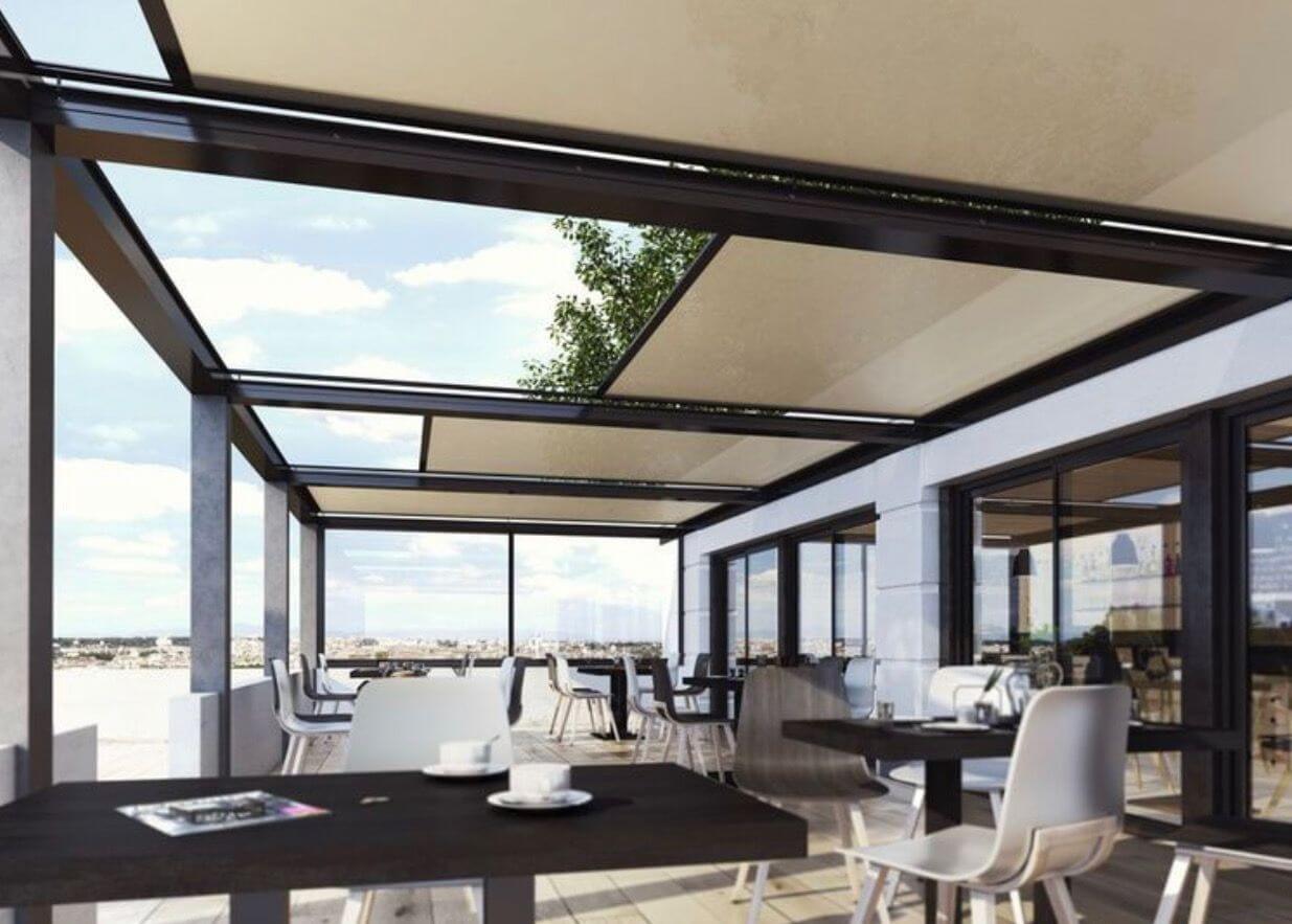 Toldo de riel cubriendo la pérgola de una terraza con mesas