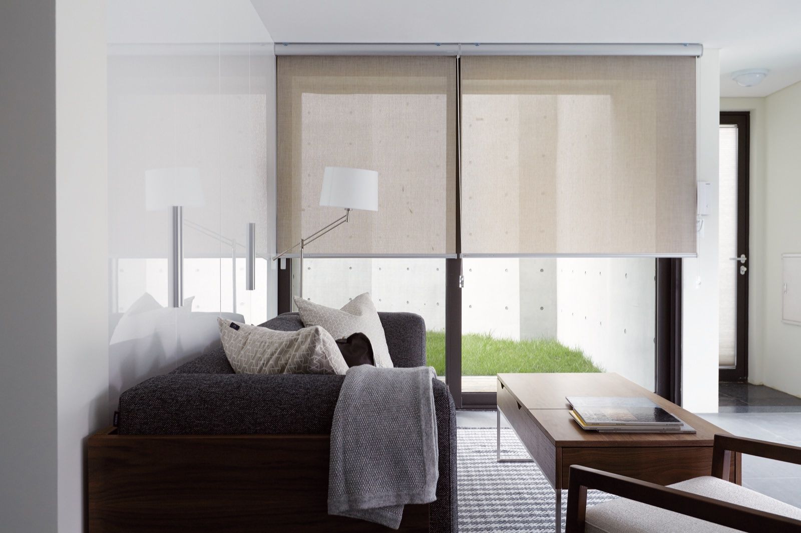 Living con cortinas roller sunscreen y vista al patio